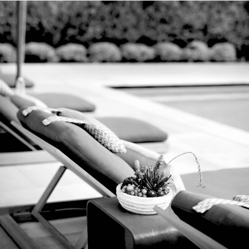 Poolside seating is captured in a black and white photograph.