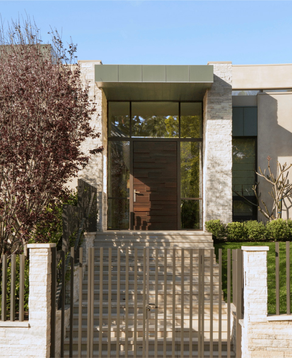 A contemporary home enclosed by an iron gate, providing security and privacy to the property.